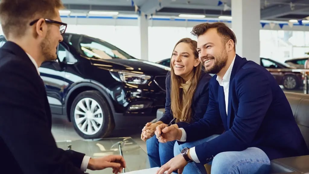 Kunden unterschreiben Leasingvertrag im Autohaus