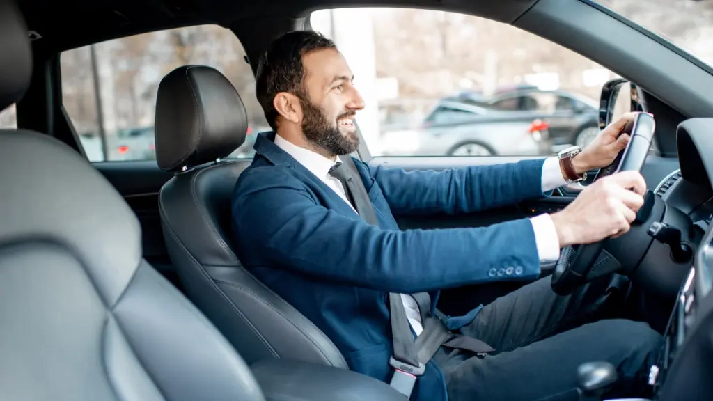 Ein Mann im Anzug sitzt im geleasten Auto.